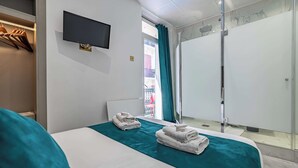 A hotel room with a bed, a TV, a bathroom with a shower, and a balcony with a view. - Hotel Avaton - Deluxe Balcony Bedroom - Cannes Palais (Cannes)