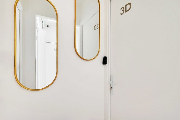 Two mirrors with gold frames on a white wall, a door with a handle, and a sign with "3D" on it. - Modern Sutdio for 2 With A/C - Near Montmartre (Paris)