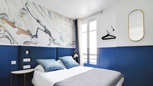 A bedroom with a large bed, a marble-patterned wall, a mirror, and a window with curtains. - Modern Sutdio for 2 With A/C - Near Montmartre (Paris)
