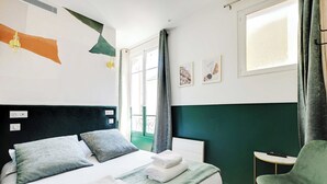 A hotel room with a bed, a chair, a window, and artwork on the wall. - Cosy Cocoon for 2P With A/C - Near Montmartre (Paris)