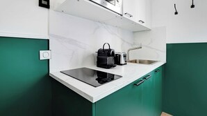 A compact kitchen with a built-in microwave, toaster, and a modern induction cooktop.