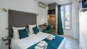 Una habitación de hotel con cama, escritorio, silla y armario.