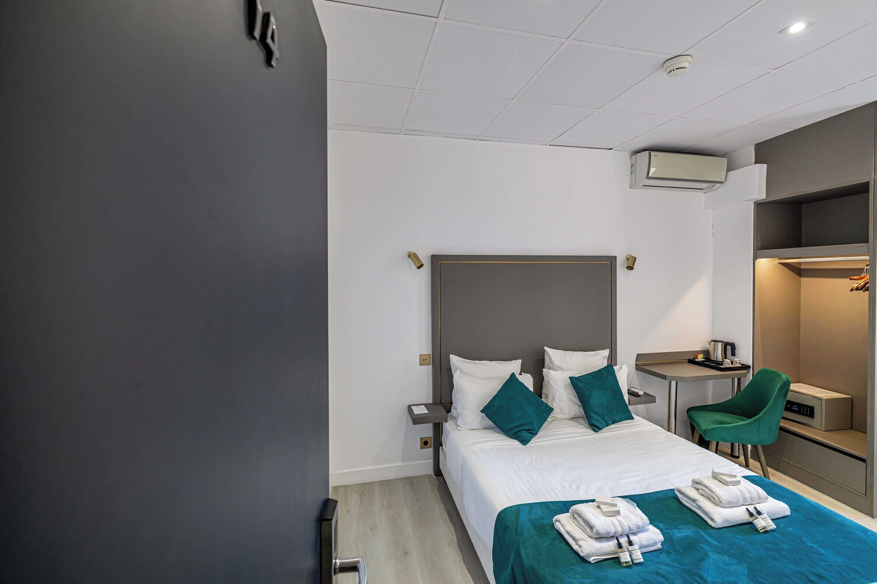 Une chambre d’hôtel moderne équipée d’un grand lit, d’un bureau, d’une chaise et d’une armoire.