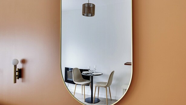A modern dining area with a round table, two chairs, and a hanging light fixture. - Magnificent Studio - 2P - Near Bastille (Paris)