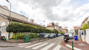A residential street with houses, parked cars, and a motorcycle. - Magnificent Studio - 2P - Next to Paris (Malakoff)