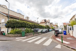 Una calle residencial con casas, coches aparcados y una motocicleta.