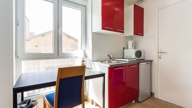 A compact kitchen with a dining area, featuring a small refrigerator, a microwave, and a sink. - Magnificent Studio - 2P - Next to Paris (Malakoff)