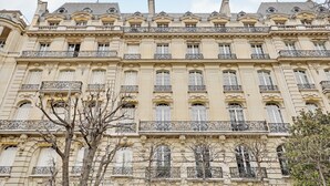 Un edificio de varios pisos con balcones ornamentados y detalles arquitectónicos clásicos.