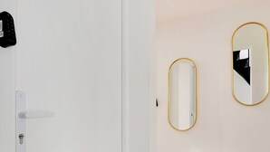 A white door with a lock and a small black device on the wall. - Cosy Studio for 2P With A/C - Near Montmartre (Paris)
