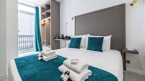A hotel room with a bed, a bedside table, a nightstand, a window with curtains, and a balcony. - Deluxe Bedroom With Balcony in Cannes Palais (Cannes)
