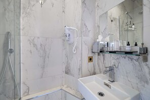 Appartement | Badkamer | Een haardroger, handdoeken, shampoo