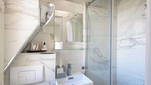 A modern bathroom with a glass shower enclosure, a built-in sink, and a mirror above the sink. - Hotel Avaton - Single Bedroom - Cannes Palais (Cannes)