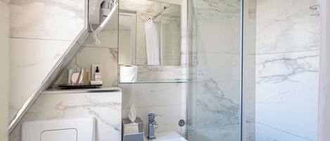Un bagno moderno con box doccia in vetro, lavabo a incasso e specchio sopra al lavabo.