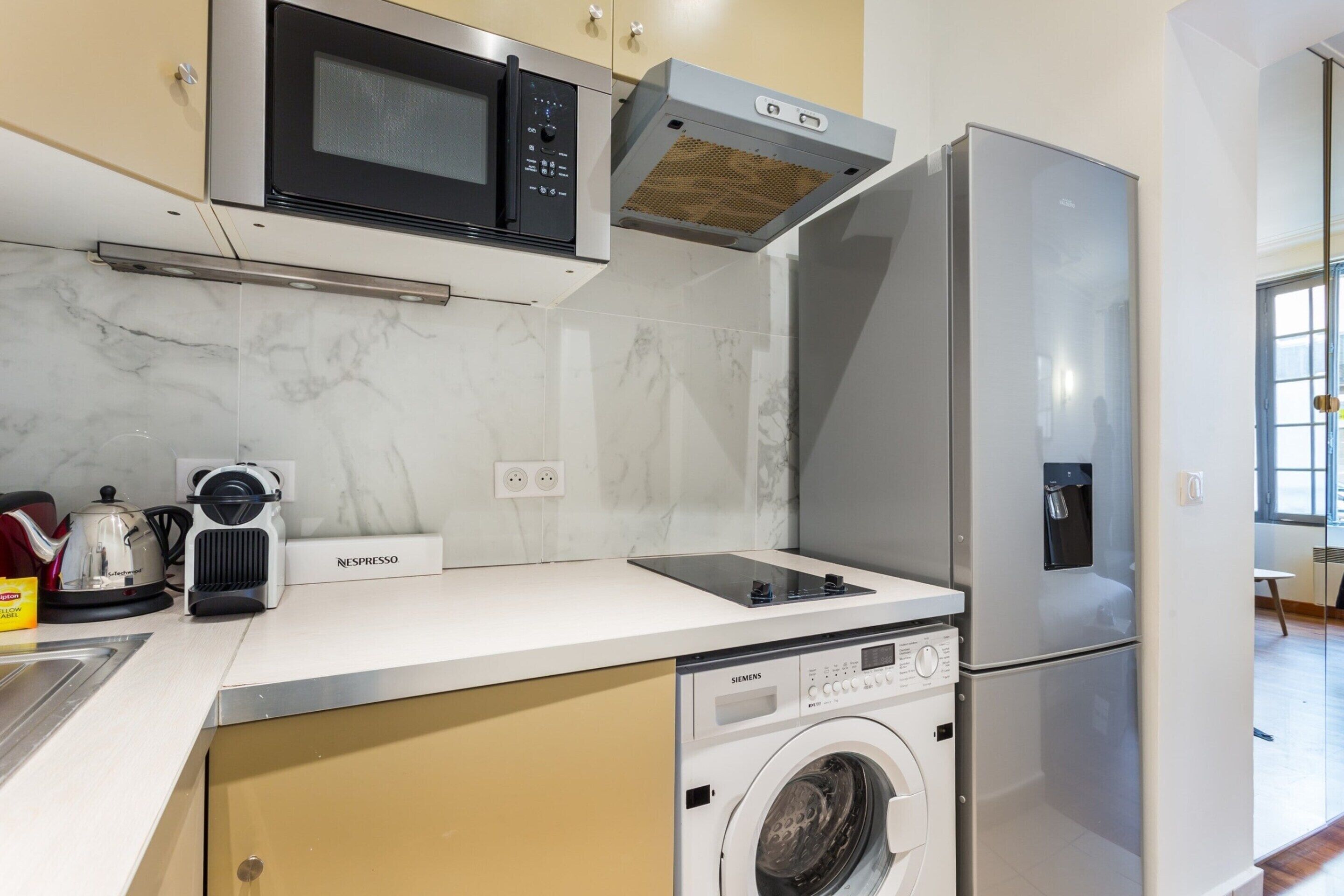 A compact kitchen with a microwave, oven, and built-in dishwasher.