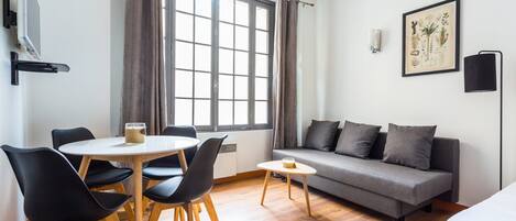 Una habitación moderna con una mesa de comedor, sillas, un sofá y una cama.