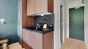 Una cocina compacta con armarios de madera, encimera negra y un grifo moderno.