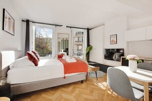 A modern hotel room with a bed, a dining table, and a TV. - Welcoming Studio for 2 People - Bastille (Paris)