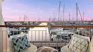 A balcony with a view of a marina filled with sailboats. There are two chairs with patterned cushions. - This apartment is a 2 bedroom(s), 2 bathrooms, located in Fremantle, WA. (Fremantle)