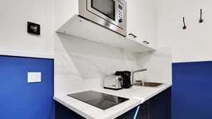 A compact kitchen with a built-in microwave, toaster, and sink. - Charming Studio - 2P With AC Near Montmartre (Paris)