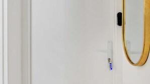 A white door with a keypad lock and a small keyhole. - Charming Studio - 2P With AC Near Montmartre (Paris)