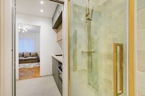 A modern bathroom with a glass-enclosed shower, a visible sink, and a wooden floor. - Peaceful Chic Studio - 2P - Arc de Triomphe (Paris)