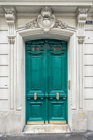 A double green door with a decorative arch above it. - Cosy and Peaceful Studio - 2P - Nation/voltaire (Paris)