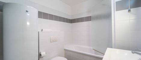 Ein modernes Badezimmer mit Toilette, Badewanne und Waschbecken.
