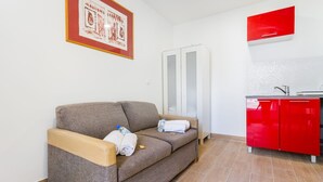 Ein modernes Zimmer mit einer Couch, einem roten Schrank und einem gerahmten Bild an der Wand.