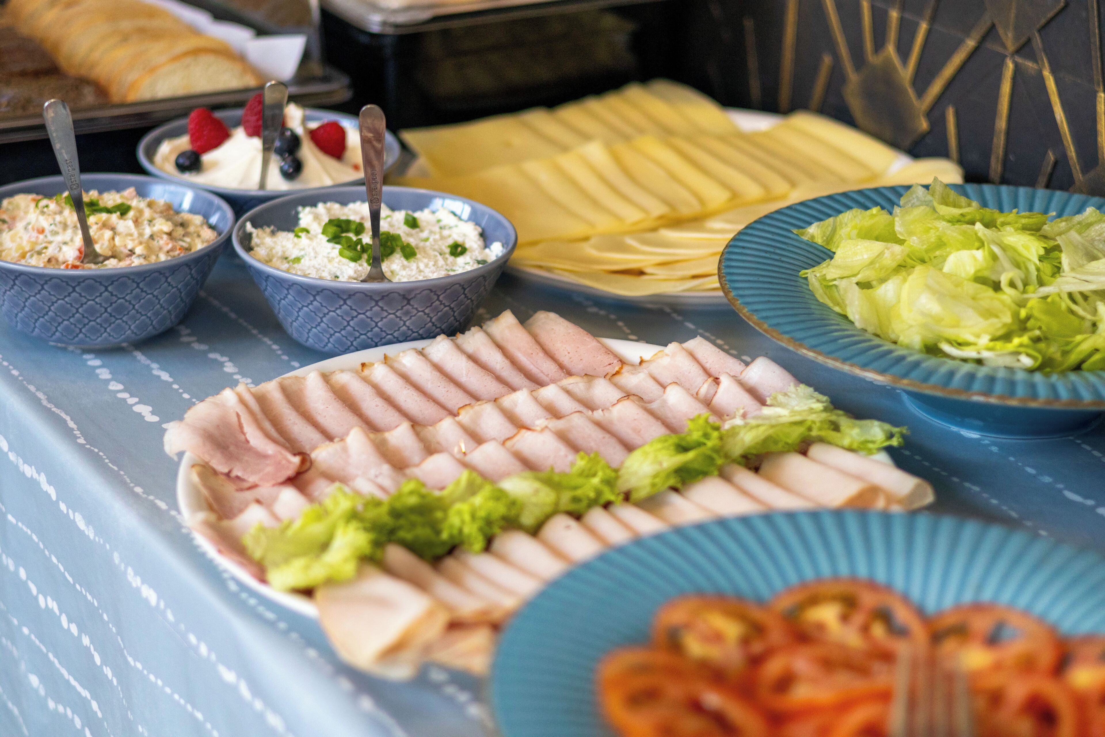 Een buffettafel met diverse gerechten, zoals vleesschotels, salades en andere maaltijden.