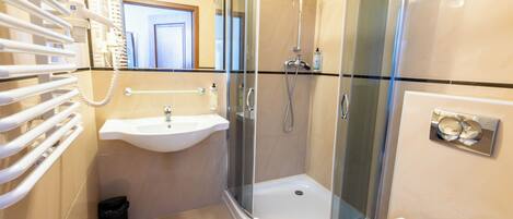 Une salle de bain moderne avec une douche à parois de verre, un lavabo et des toilettes.