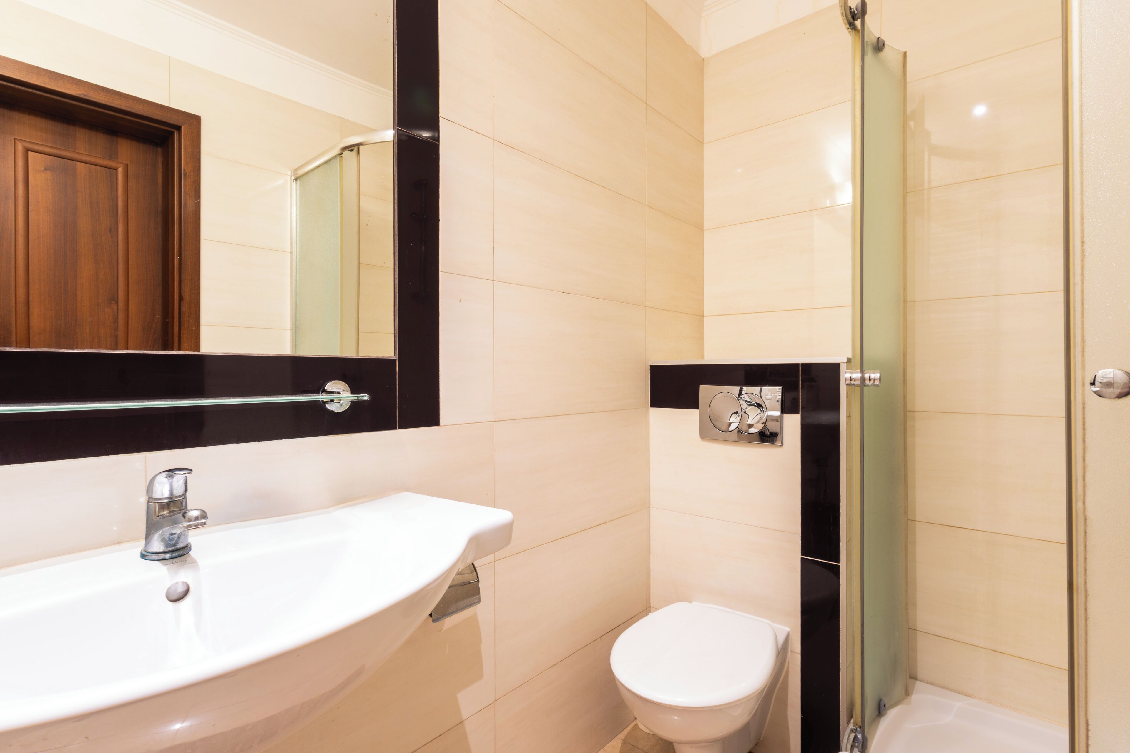 Een badkamer met een wastafel, toilet en een douchecabine met glazen wanden.