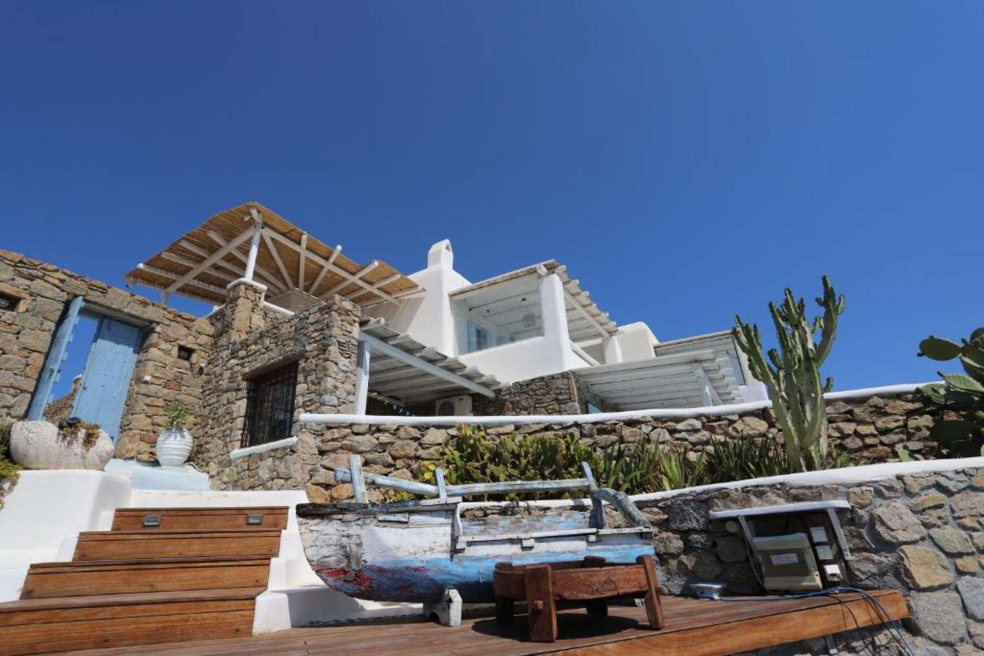 A stone building with a wooden deck and a boat.