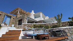 Ein Steinhaus mit einer Holzterrasse und einem Boot.