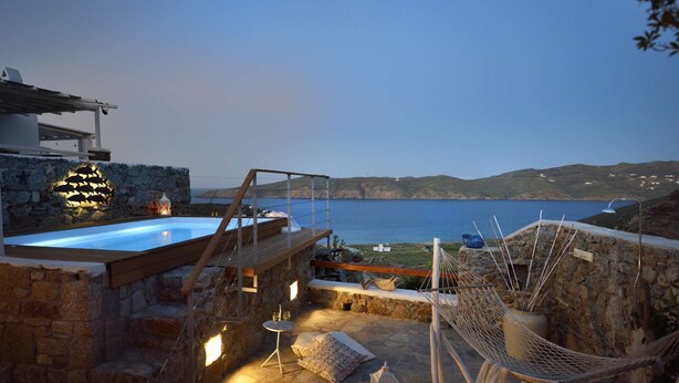 A rooftop terrace with a swimming pool, stone walls, and a hammock. - Villa Princess 6 private with Pool Panormos Beach (Mykonos)