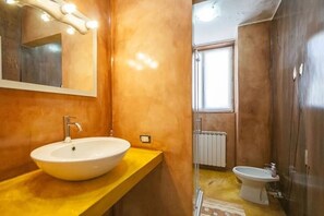 Een douche, een haardroger, een bidet, handdoeken