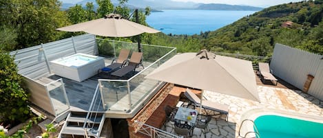A rooftop terrace with a hot tub, outdoor seating, and a swimming pool.