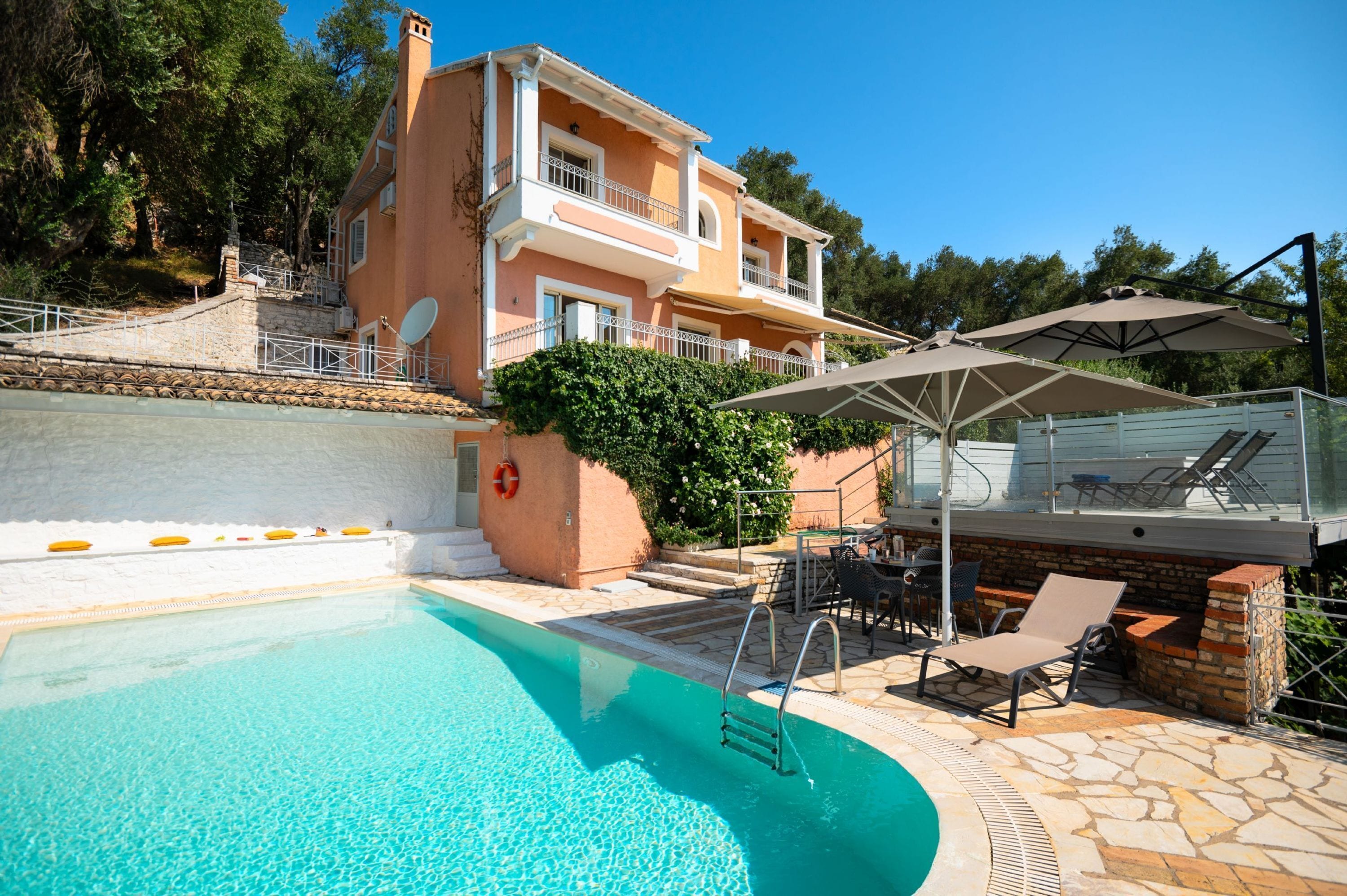 A two-story house with a swimming pool, outdoor seating, and a covered patio area.