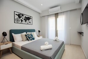 Una camera d'hotel moderna con un letto, un'opera d'arte raffigurante una mappa del mondo, un condizionatore d'aria e una televisione.
