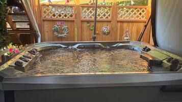 A hot tub with a wooden deck and a covered area.