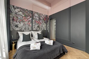A bedroom with a large bed, a wardrobe, and a patterned wall. - Waterlane Vintage Fitness & Gym by Downtown Apartments (Gdansk)