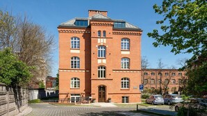 A red brick building with a symmetrical facade, large windows, and a central entrance.