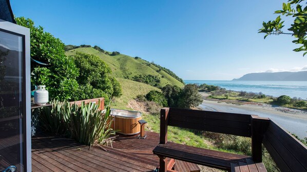 Una terraza de madera con un banco que da a un paisaje costero.