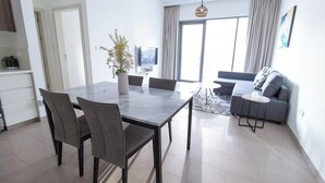 Una sala de estar moderna con comedor, sofá y televisor.