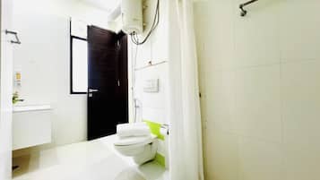 Ein Badezimmer mit Toilette, Waschbecken und Duschbereich.