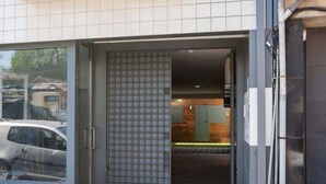Une entrée moderne, avec une porte en verre donnant sur l’intérieur du bâtiment.