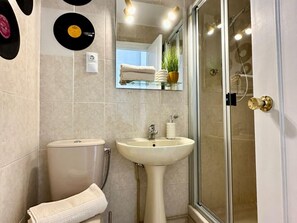 Un bagno con WC, lavandino e cabina doccia in vetro.