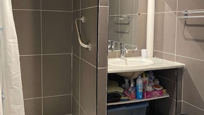 A bathroom with a shower, a sink, and a mirror. - Comfortable studio with air conditioning and wifi in Balaruc-les-Bains (Balaruc-les-Bains)