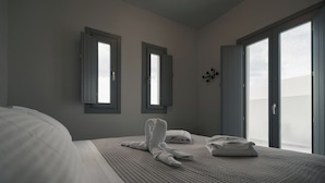 Una habitación de hotel con una cama grande, dos ventanas y vista al cielo.
