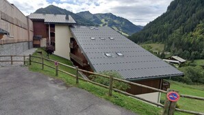 A rustic building with a sloped roof and wooden balconies, surrounded by a mountainous landscape. - Cozy studio in Châtel, near center, with mountain corner, parking and balcony (Châtel)
