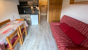 A compact living space with a dining area, kitchenette, and a sofa. - Cozy studio in Châtel, near center, with mountain corner, parking and balcony (Châtel)